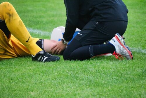 soccer player being examined by athletic trainer